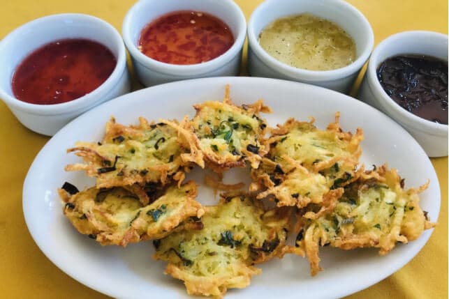 Bolinhos de batata servidos com alguns molhos